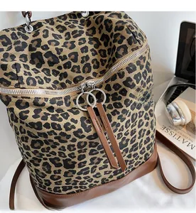 Detail von glattem Metallreißverschluss und braunen Lederlaschen an Leoparden-Rucksack