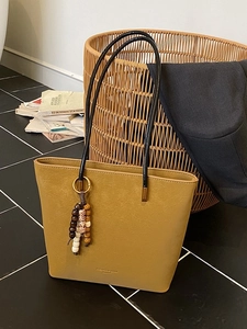 Borsa tote giallo senape in ecopelle con nappa in perline di legno per il pendolarismo