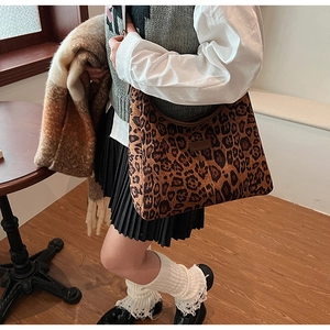 Vista laterale della borsa hobo leopardata indossata da una modella in un interno vintage