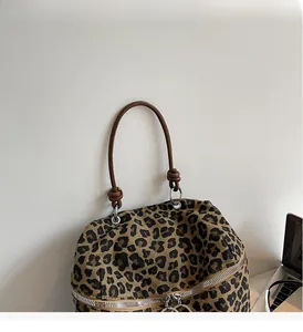 Detail der Canvas-Tasche mit Leopardenmuster, braunen Kunstledergriffen und Silberteilen