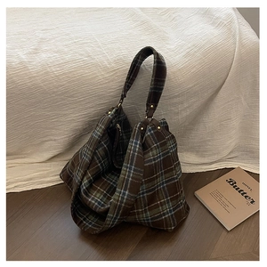 Close-up of vintage plaid wool tote bag with metal rivets and internal pocket detail