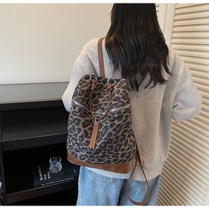 Detailansicht eines Canvas-Rucksacks mit Leopardenmuster und Lederboden am Modell