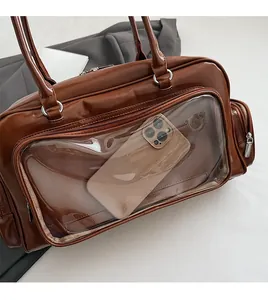 Detailed view of brown leather tote bag featuring a transparent front phone compartment