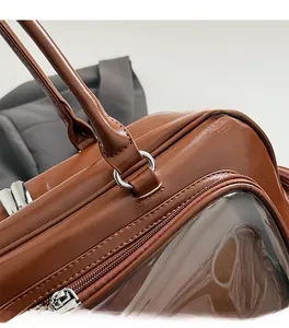 Detailed close-up of brown PU leather handbag with silver hardware and dual zippers