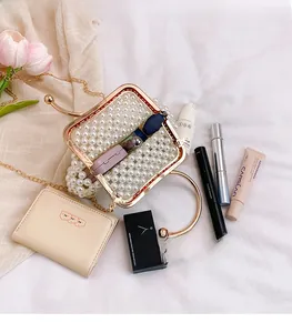 Macro view of handmade pearl handbag interior holding cosmetics with gold metal frame