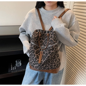 Detail des Rucksacks mit Leopardenmuster, braunem Lederbesatz und Kordelzugverschluss