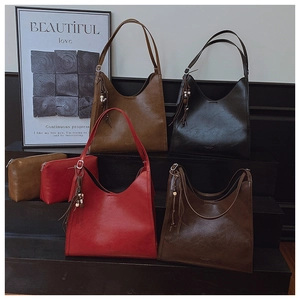 Détail de sacs cabas vintage en cuir ciré avec perles en bois et pompons décoratifs