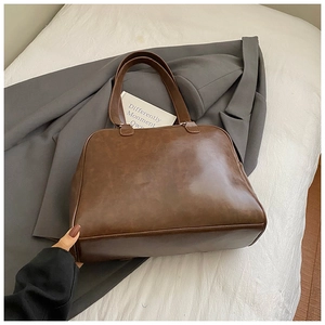 Detail of vintage brown leather pillow tote bag texture and long shoulder handles