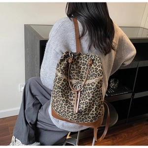 Leopard-Leinwand-Rucksack mit braunen Lederdetails, von Model im Wohnbereich getragen
