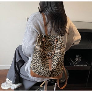 Detail eines Rucksacks mit Leopardenmuster, Lederboden und verstellbaren Trägern
