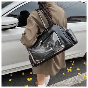 Detail of black leather tote bag with transparent PVC panel and side zip pocket outdoors