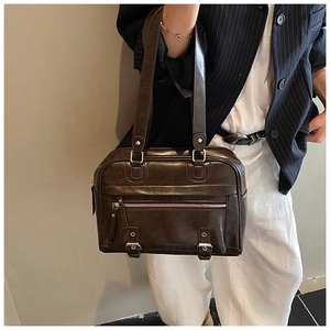 Brown retro pillow shoulder bag in oil wax leather texture worn with a striped blazer