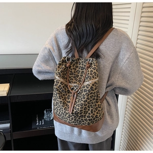 Detail eines Leoparden-Rucksacks aus Canvas mit braunem Lederbesatz an einem Model