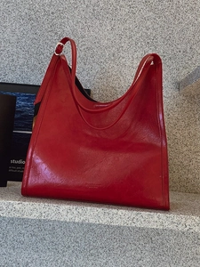 Retro red faux leather tote bag with silver buckle on dark stone steps for women