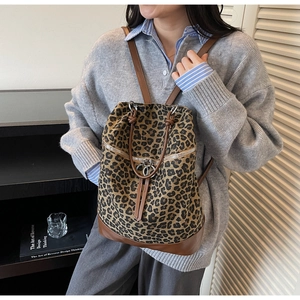Detailansicht eines Rucksacks mit Leopardenmuster und braunem Lederboden am Modell