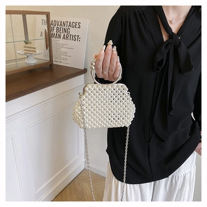 Detail of handmade pearl beaded handbag with silver metal handle and chain strap