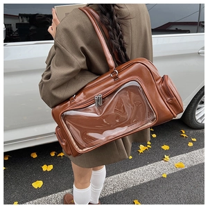 Detail of a brown leather itabag with a clear PVC window and silver zipper hardware