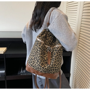 Schicker Rucksack mit Leopardenmuster und braunem Lederbesatz, getragen von Model