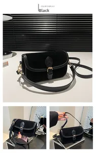 Detail of black vintage velvet and leather crossbody bag with gold buckle and adjustable strap