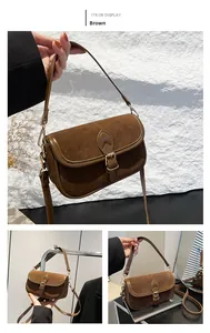 Detail view of brown vintage shoulder bag with textured suede and smooth leather stitching