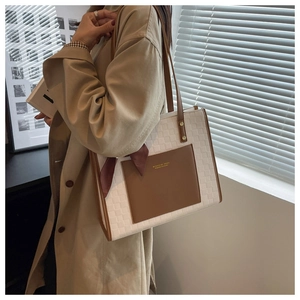 Détail du grand sac cabas tissé blanc avec poche en cuir marron et foulard décoratif