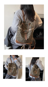 Detail eines Rucksacks mit Leopardenmuster, braunem Lederbesatz und Metallring