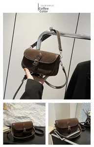 Detail view of coffee brown suede crossbody bag with vintage leather heart buckle trim