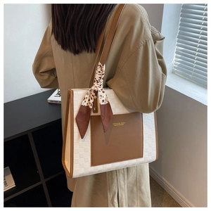 Détail du cabas à damier avec poche en cuir marron et foulard en soie sur modèle