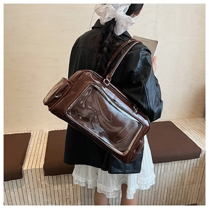 Detail of a deep brown glossy Ita bag with clear window and side zipper pocket