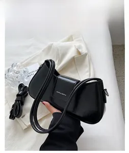 Detail showing glossy black patent leather shoulder bag with silver hardware and strap