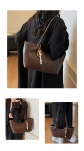 Détail du sac cabas marron foncé avec texture vintage et accessoire de charme perlé