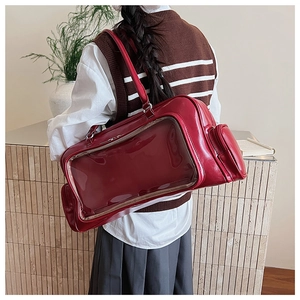 Detail view of red oversized tote bag with a clear PVC window for pin display