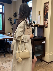 Chic beige rectangular underarm bag with small pouch shown in vintage cafe setting
