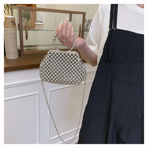 Detail of silver beaded handbag with round metal handle and long crossbody chain strap