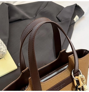 Close-up of the leather canvas patchwork tote bag with silver zipper and charm