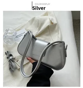 Detailed shot of the metallic silver baguette bag with its adjustable long shoulder strap