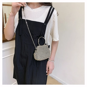 Detail of silver beaded mini handbag with metal ring handle and crossbody chain