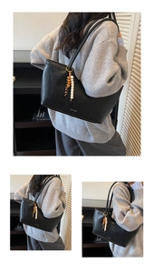 Détail du sac cabas tressé noir avec logo métallique et accessoire de perles en bois