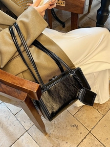 Chic black bowling shoulder bag in glossy leather texture with mini charm pendant