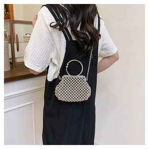 Chic silver beaded handbag with metal round handle and chain strap on a model