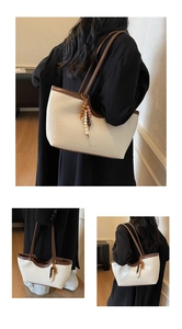 Détail du sac cabas tissé blanc avec breloques perlées vintage et bordure ondulée