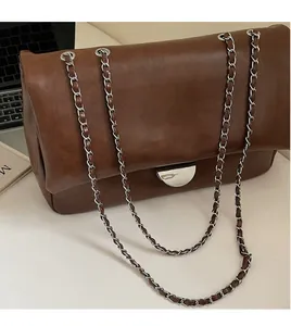 Detail der silbernen Kettenriemen und Metallschnalle an brauner Vintage-Ledertasche