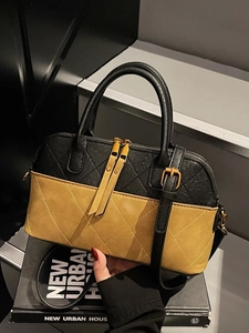 Chic quilted shell bag in black and mustard yellow leather with dual handles and crossbody strap