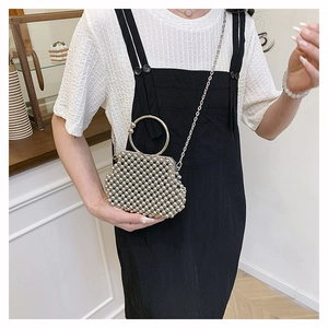 Silver bead crossbody bag featuring a round metal handle and a long chain strap