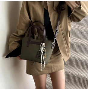 Detail of olive green canvas bag with chocolate charm and elegant thick chain strap