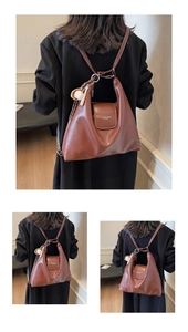 Detail of brown leather tote bag with Fashion & Bags text and baseball charm accessory