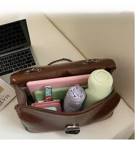 Detail der geräumigen braunen Ledertasche mit Laptop und täglichen Utensilien