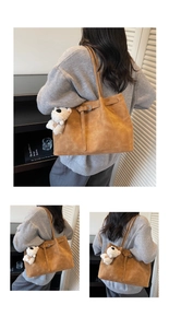 Detailed view of caramel suede tote bag featuring a buckle strap and plush dog charm