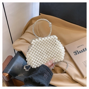 Detail of handmade pearl beaded handbag with silver metal handle and clasp closure