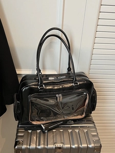 Large black glossy handbag with a transparent front PVC pocket and silver zippers